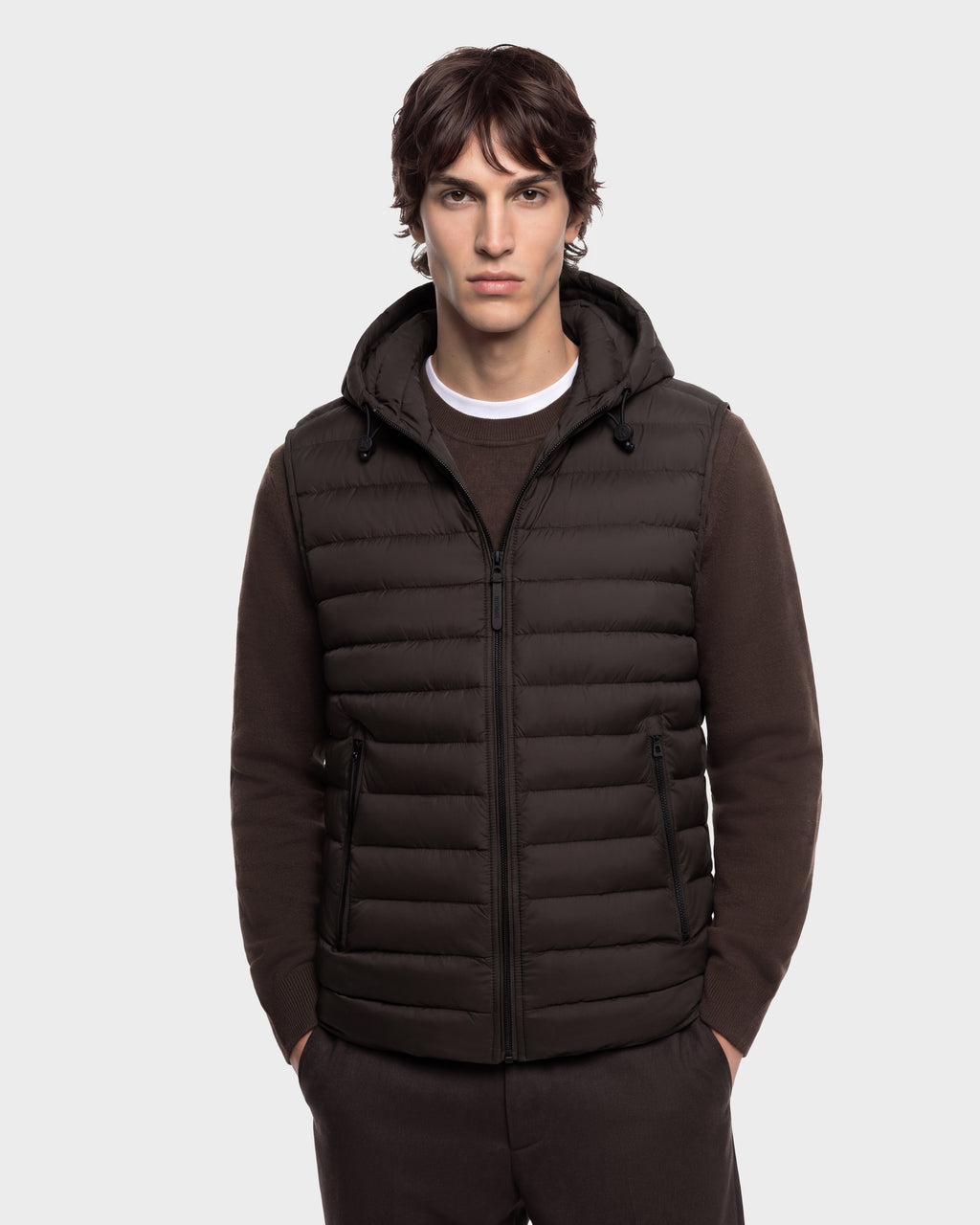 A man wearing a BRUNO - 6126716 Espresso dark brown hooded puffer vest over a matching sweater.