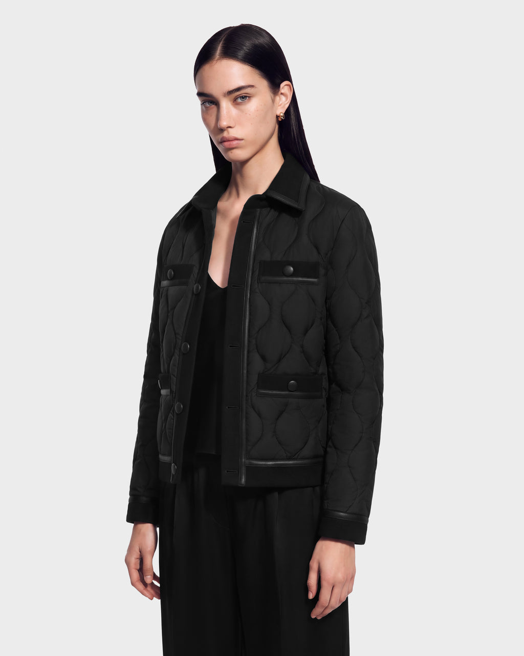 A RUDSAK model wearing a JOLIE - 8125036 Black RDS-certified down quilted jacket featuring a button-up front and two chest pockets.