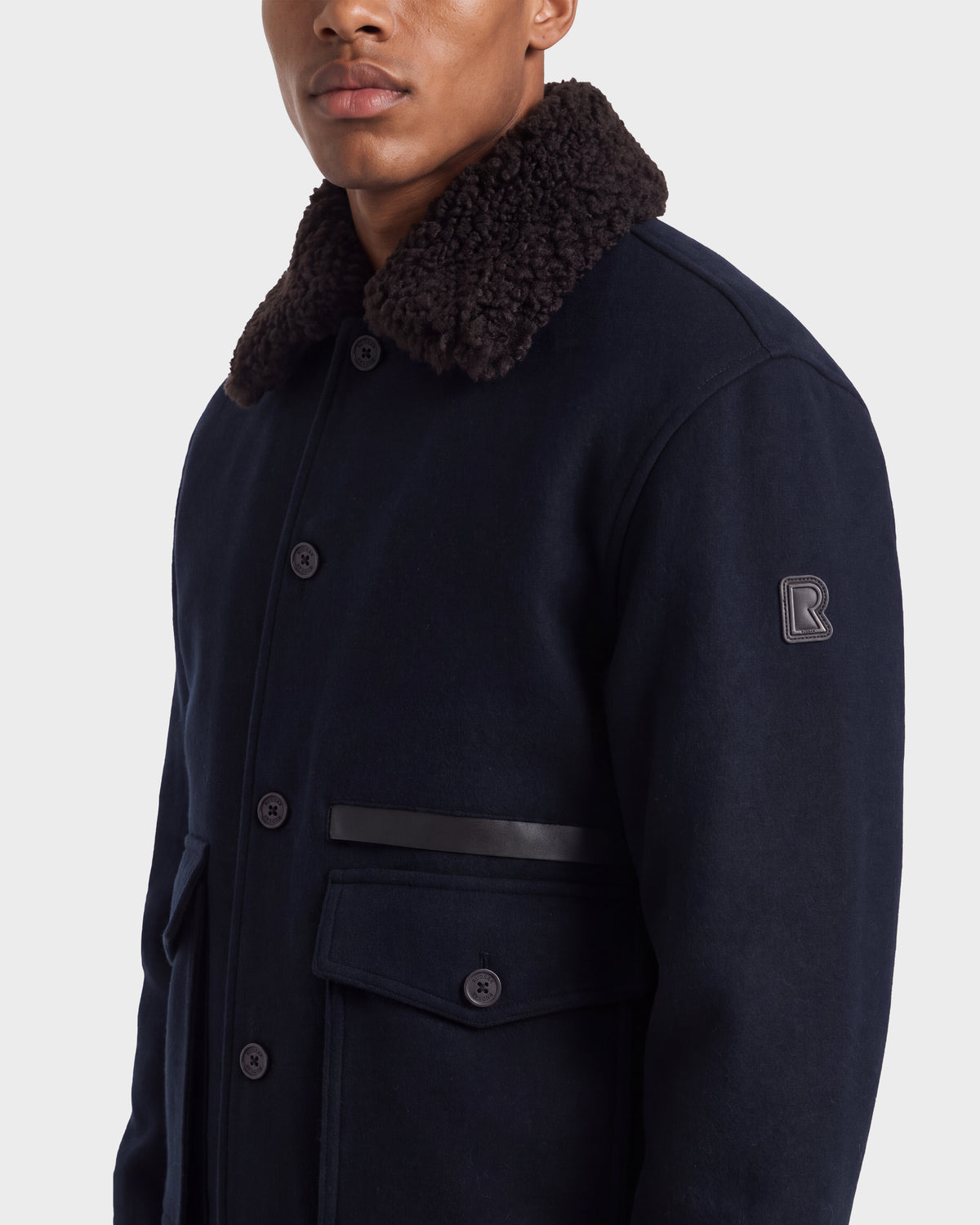 A Rudsak JULIUS - 6126723 Navy wool-blend coat featuring a dark shearling collar, button-front closure, and flap pockets.