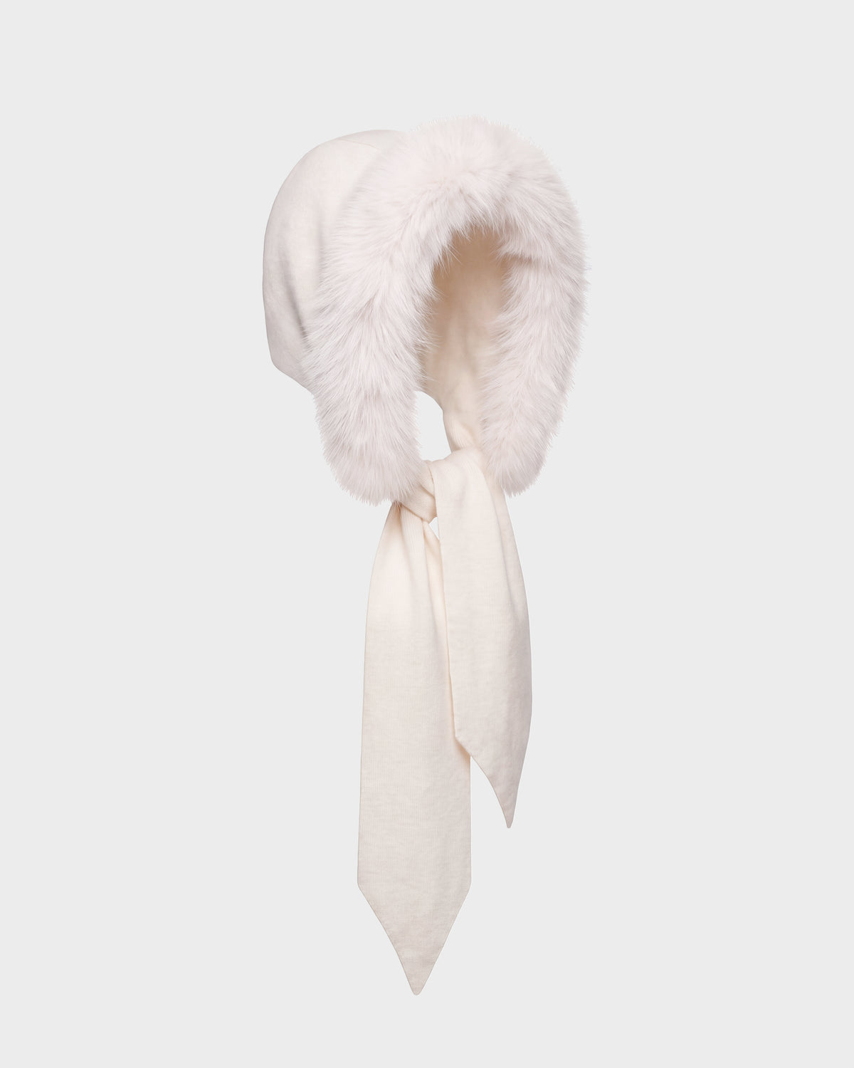 The KARYMA - 8426507 Vanilla bonnet by Rudsak is a white winter hat featuring a fluffy faux fur trim around the face opening and long fabric ties that hang down in front, displayed on a plain light grey background.