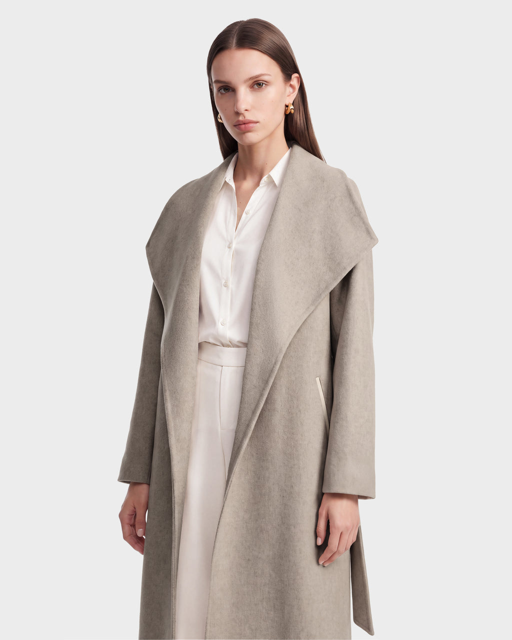 A woman wearing the Rudsak CINDY - 8126526 Heather Vanilla light gray wool cashmere coat over a white blouse and pants stands against a plain white background, looking at the camera with a neutral expression.