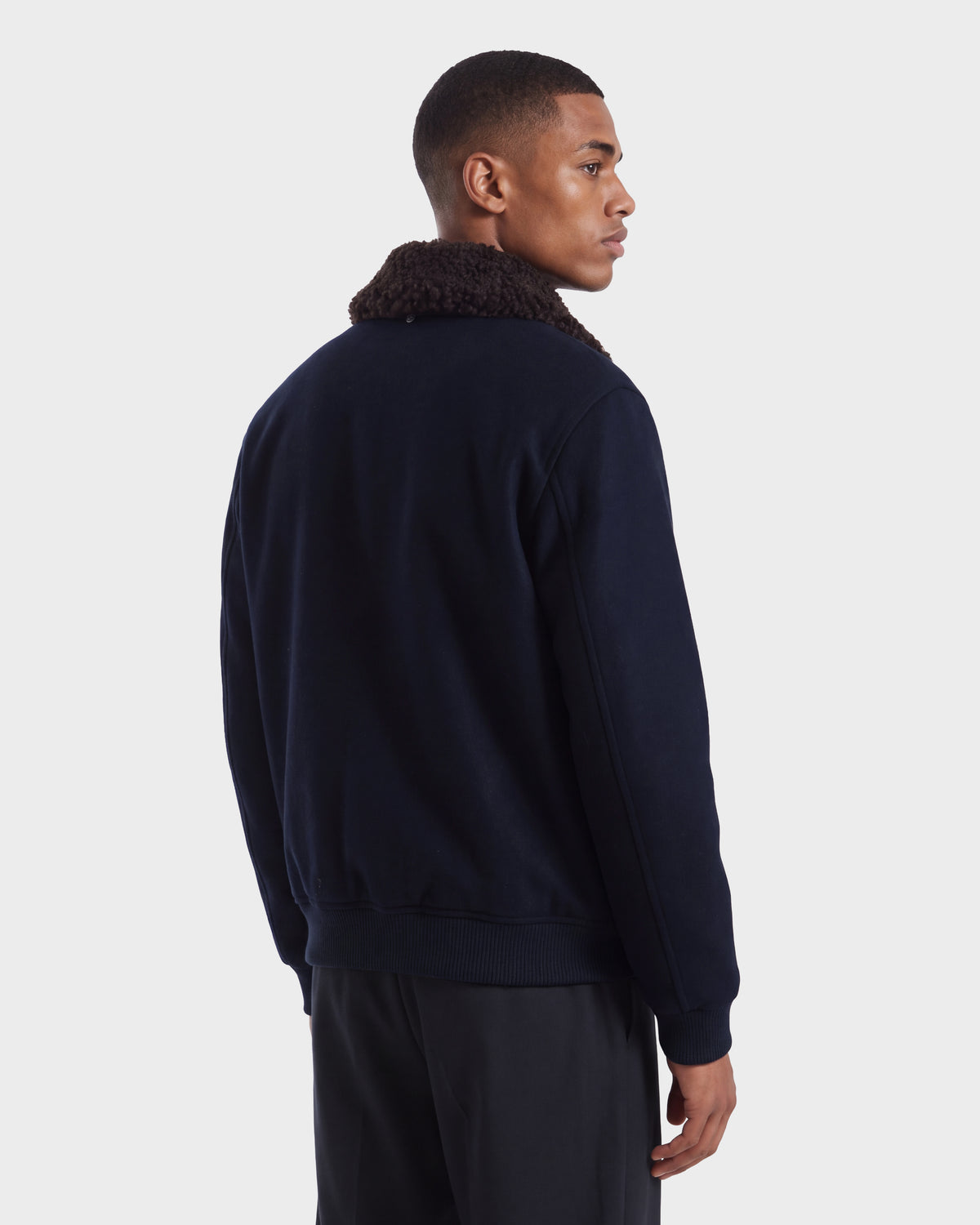 Man wearing a Rudsak JULIUS - 6126723 Navy bomber jacket with a dark navy finish and a dark brown faux-shearling collar.