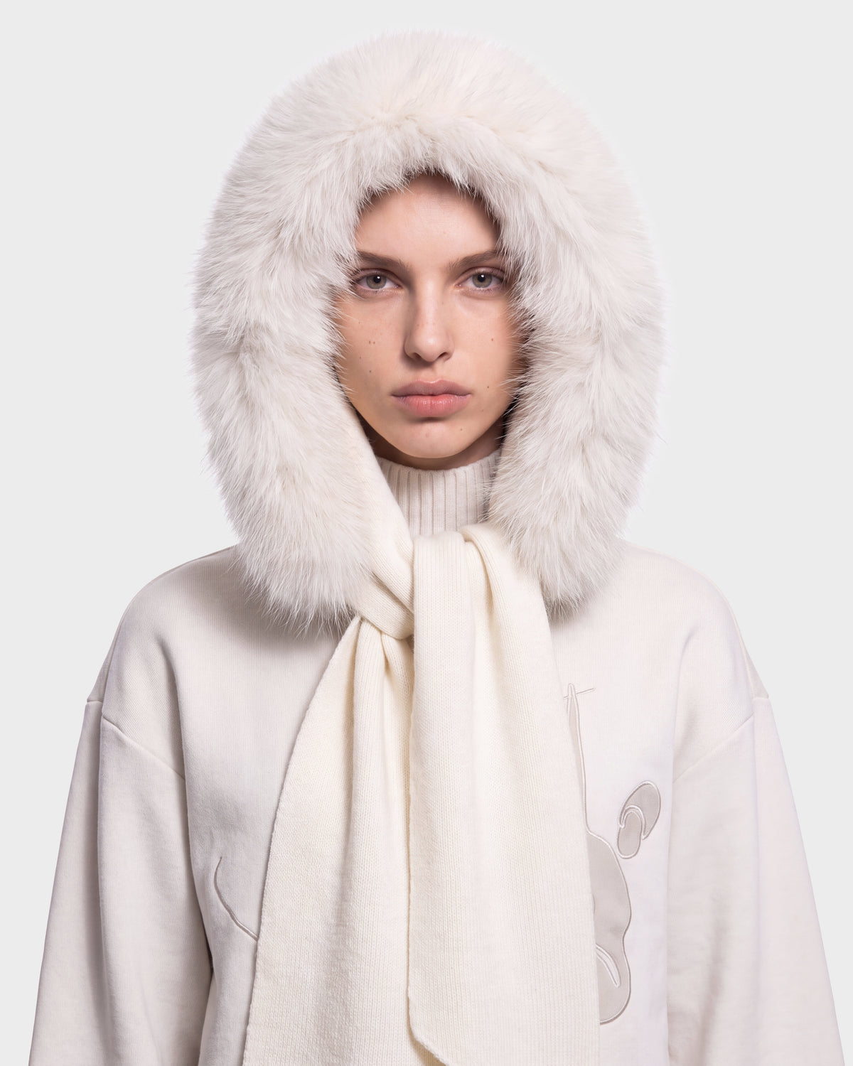 A person wearing the Rudsak KARYMA - 8426507 Vanilla fluffy white hood and matching scarf over a high-neck light sweater, looking straight ahead with a neutral expression, on a plain light background.