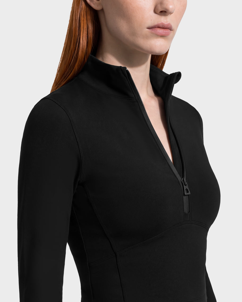 A person wears a black ANITA - 8526579 cropped, performance-inspired long-sleeved shirt with a mock neck and a quarter-length front zipper.