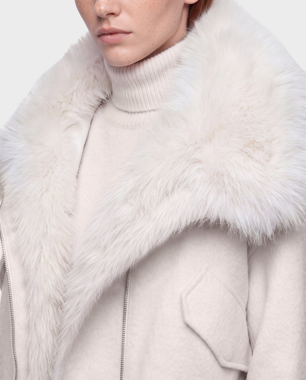 A cream-colored ZARIA - 8126999 Vanilla winter puffer with a thick faux-fur collar worn over a matching turtleneck sweater.