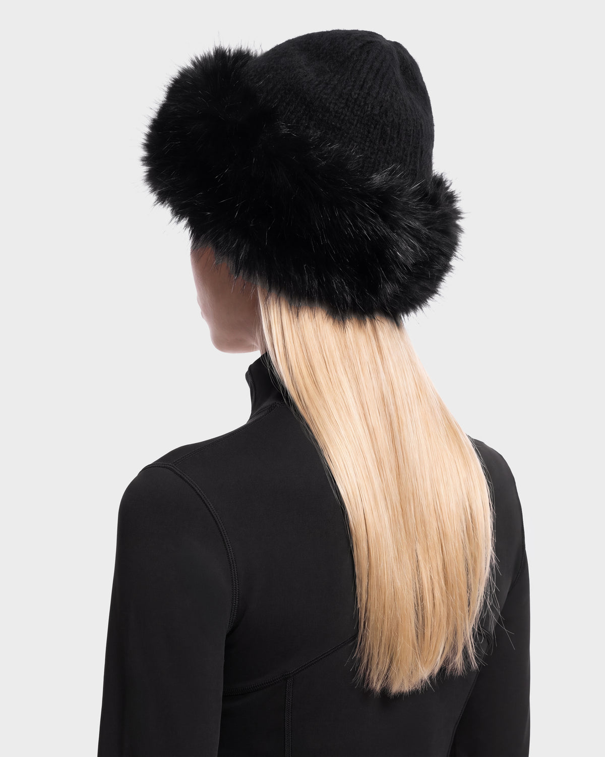 Back view of a person wearing a black LORETTA W - 8426510 Black knit hat by Rudsak featuring a wide faux fur brim.