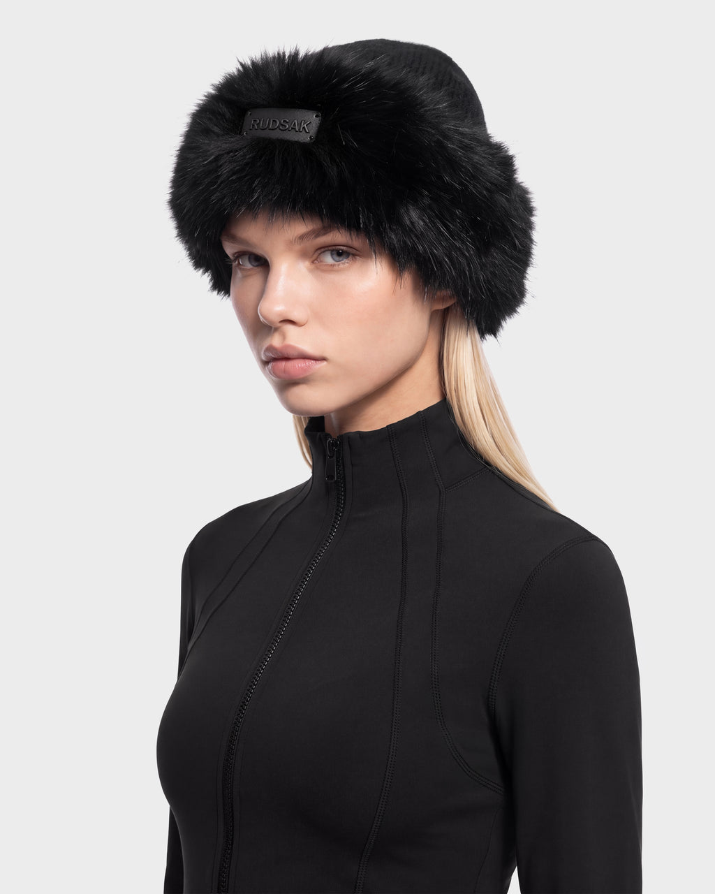 A model wears a black LORETTA W - 8426510 Black hat by Rudsak with a wide faux fur trim.