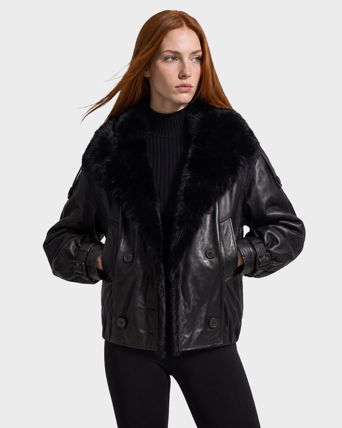 Woman wearing a JANELLE - 8126936 Black leather bomber jacket with a faux fur collar and double-breasted buttons.