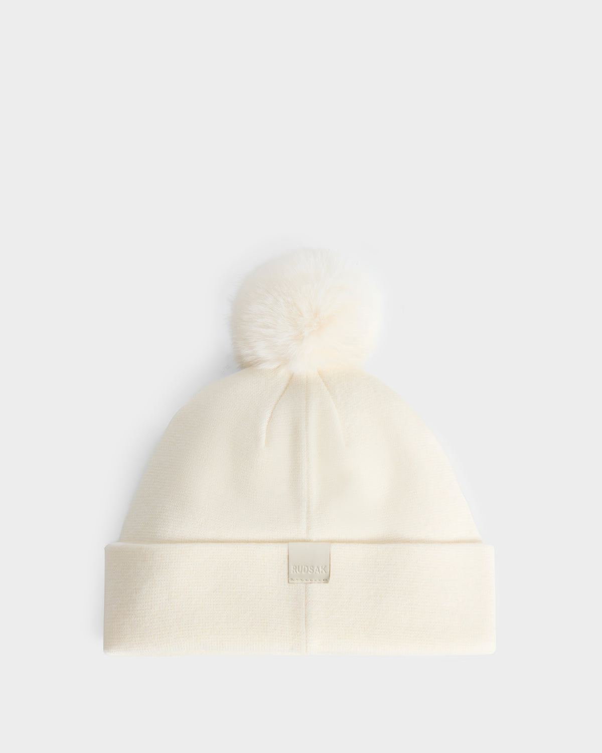 Rudsak ESTELLA - 8426521 Vanilla cream-colored knit beanie featuring a matching faux-fur pom-pom and a small rectangular logo patch on the cuff.