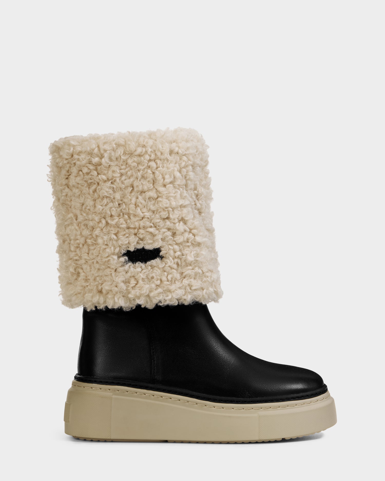 The Rudsak MIKIE L - 8225580 Black women’s leather boot features a thick beige sole and a tall, folded-over cream shearling cuff. This chic boot is displayed in profile against a plain background.