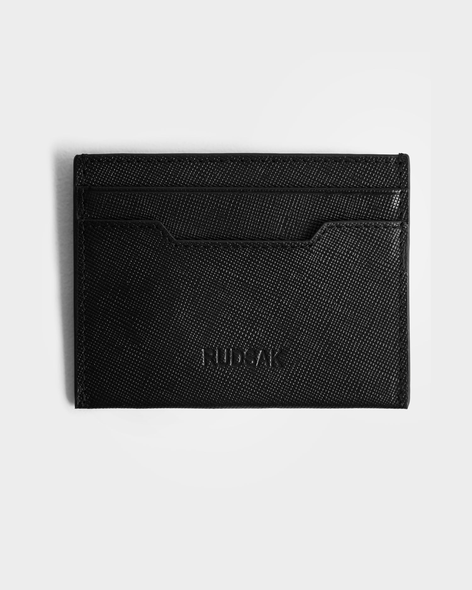 The RYLIE - M424500 Black by Rudsak is a black textured leather cardholder with three slots and an embossed logo—an ideal addition to any men’s box set or gift box.