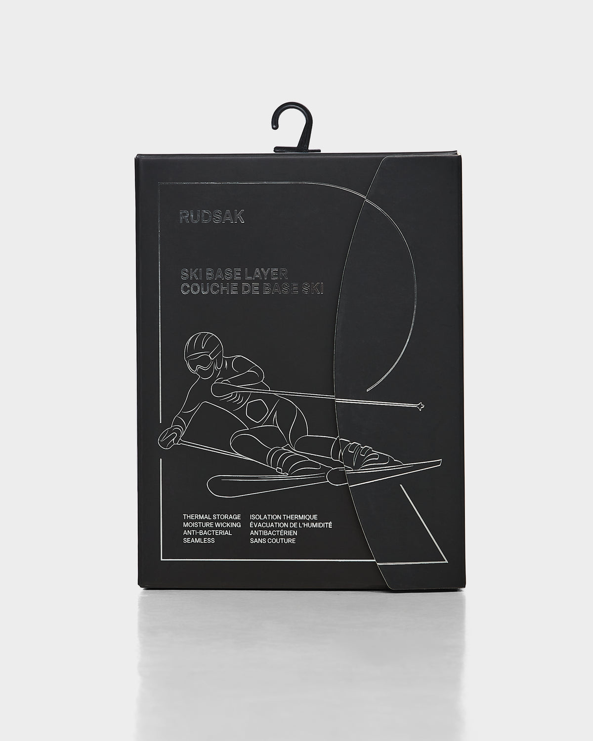 A black rectangular package for the Rudsak CARRIE - 8524619 ski underlayer features a minimalist white skier line illustration. Packaging details are in English and French and highlight women’s stretch set thermal performance.