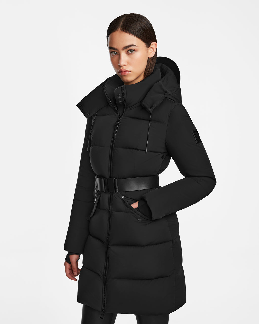 A woman wearing the Rudsak CAT - 8124584 Black mid-length puffer coat.
