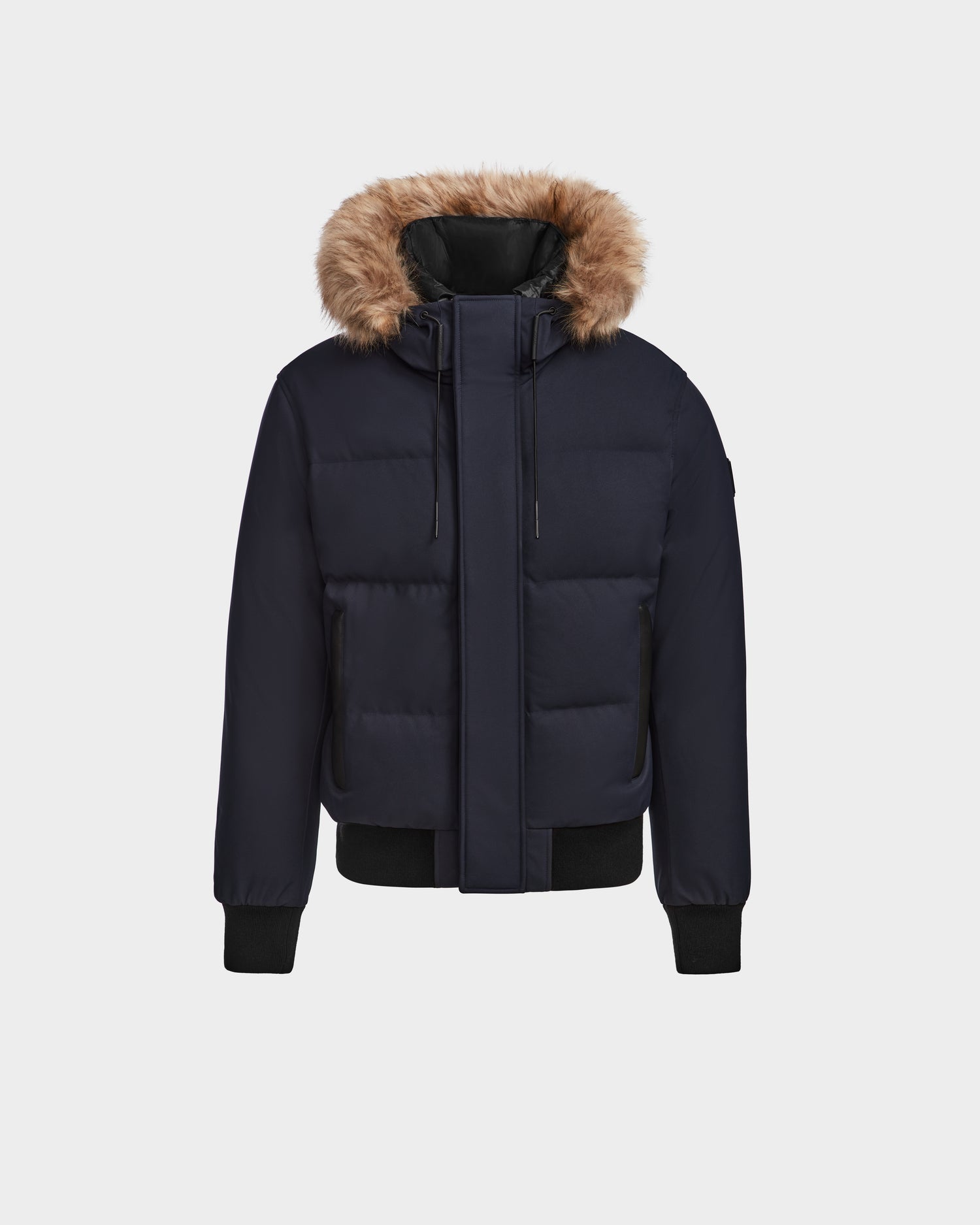 The Rudsak DALLAS - M122501 Navy men's bomber is a quilted down jacket with a fur-lined hood, front zipper, snap buttons, and black ribbed cuffs and hem, made from RDS-certified down, shown on a plain light background.