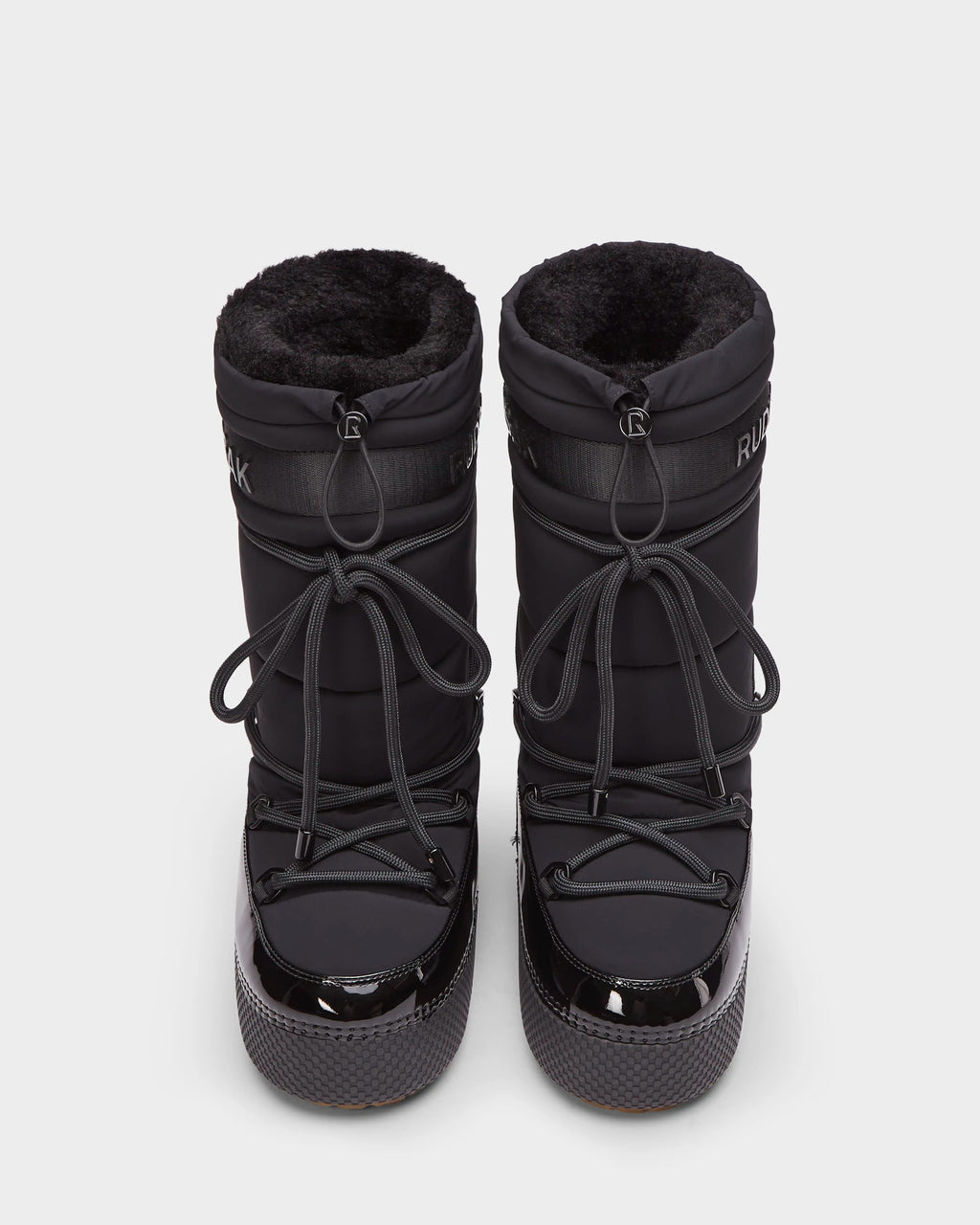 A pair of Rudsak FARAH L - 8224542 black women’s winter boots with thick soles, round toes, lace-up fronts, and faux fur lining, shown from above on a white background.
