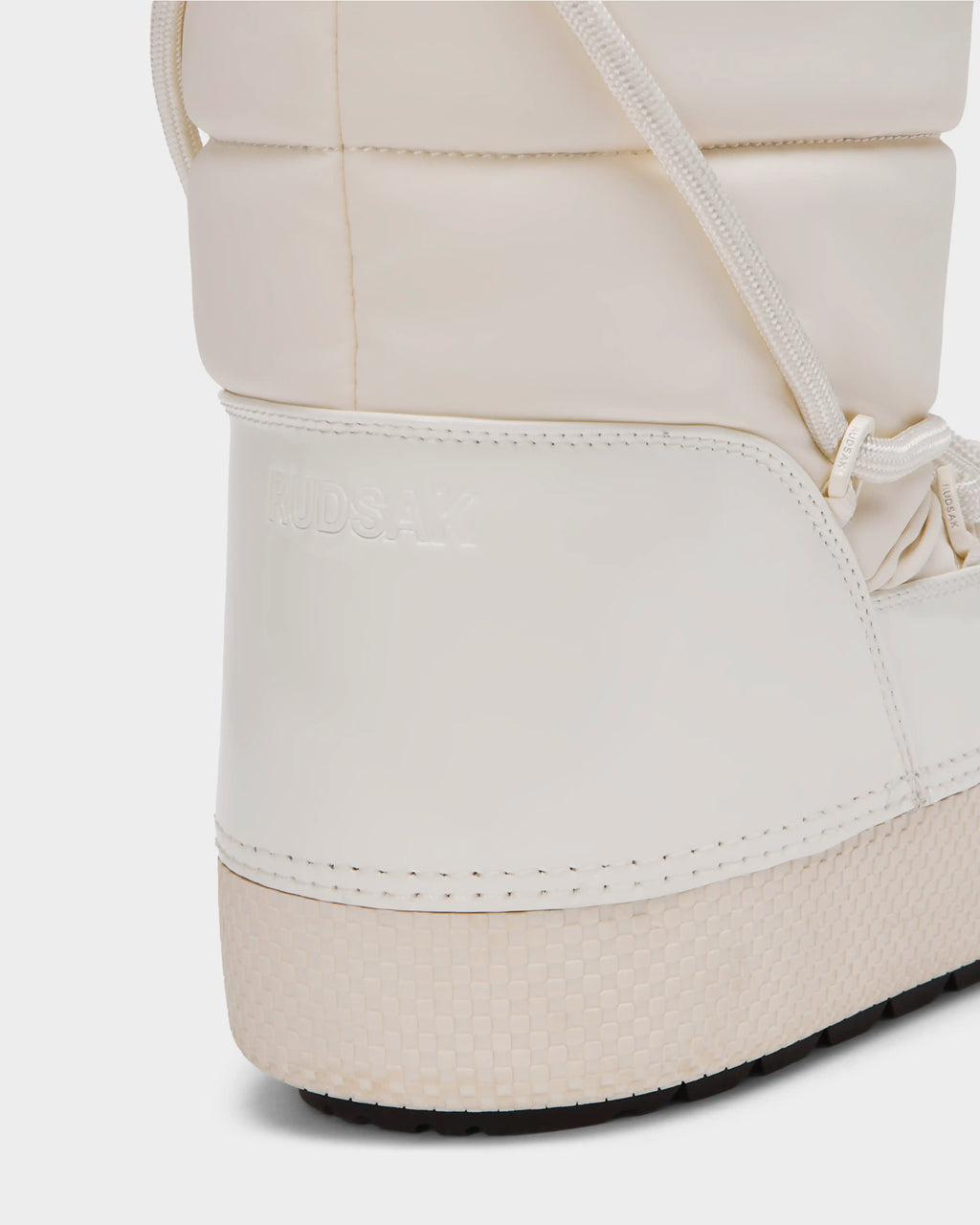 Close-up of the heel and side of the white FARAH L - 8224542 Iceland women’s winter boot by Rudsak, featuring a textured sole, visible stitching, faux fur lining, and RUDSAK embossed on the side.