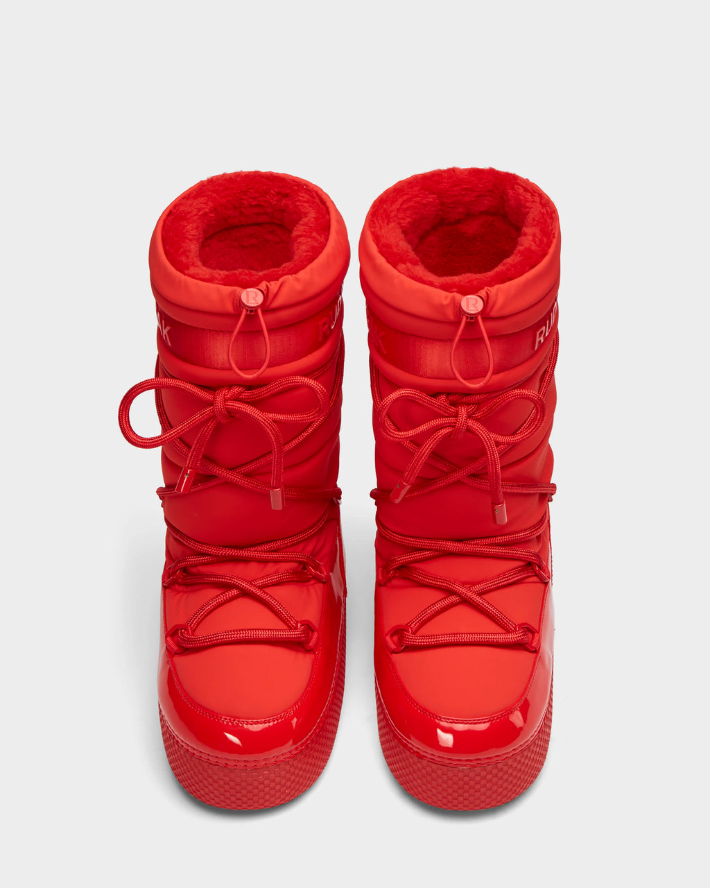 The Rudsak FARAH - 8223501 Flame Red boots feature thick soles, round toes, red laces, and a soft red lining for warmth. Water-repellent and viewed from above, their bright red color stands out.