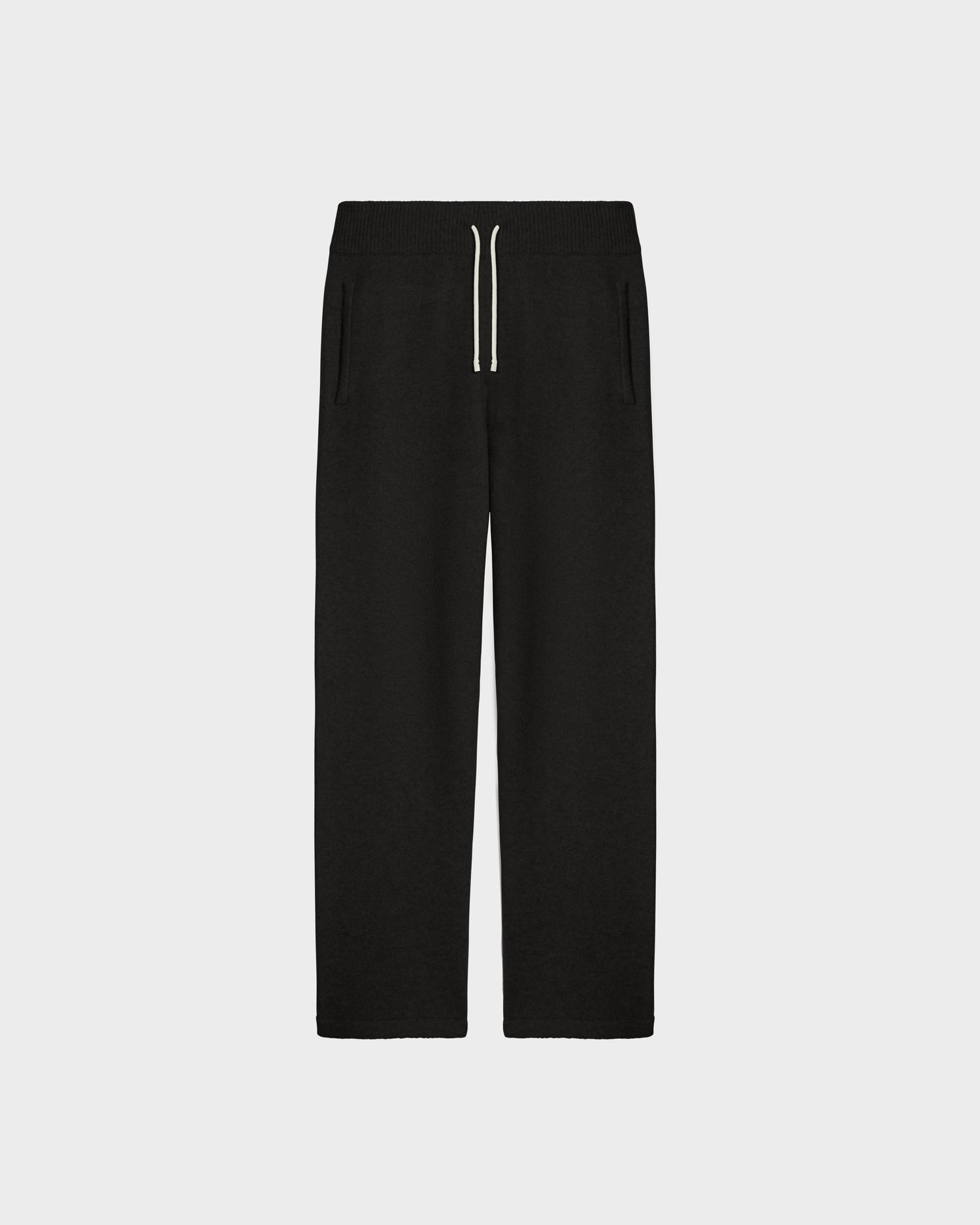 The Rudsak GEIGER - 9524512 Black W lounge pants feature an elastic waistband, white drawstring, and side pockets. These unisex knit pants combine comfort and style, displayed on a plain white background.