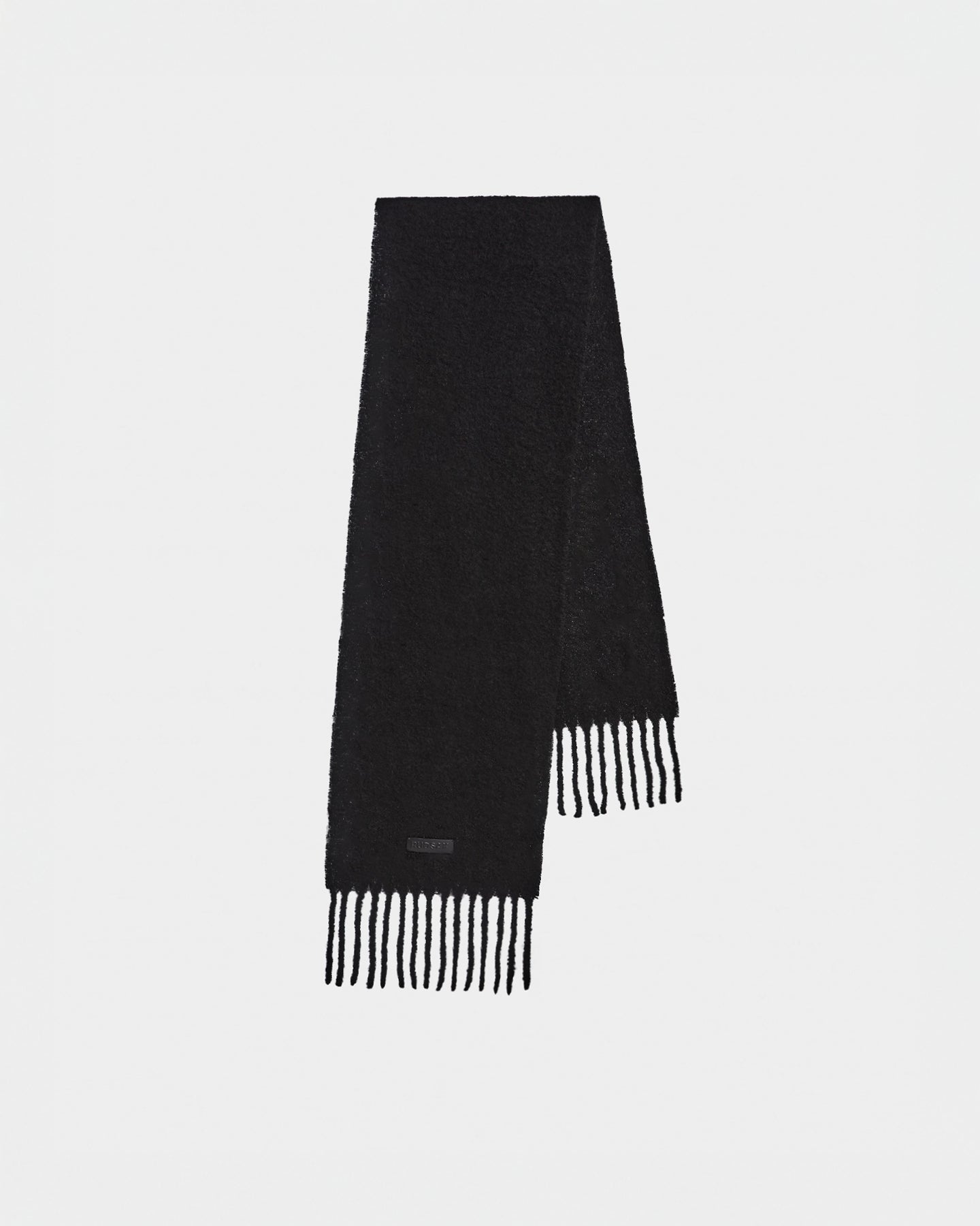 The HAILEE - 9424507 Black scarf by Rudsak is a long, unisex winter accessory with fringed ends and a small black label near the edge, displayed against a white background.