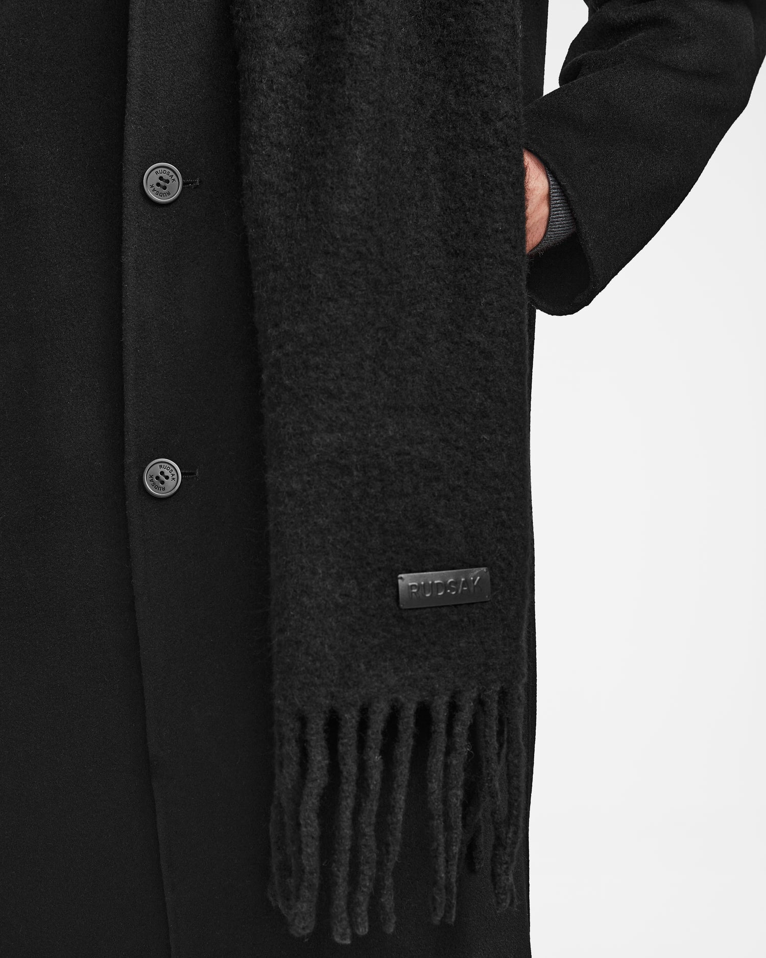 Someone wearing the Rudsak HAILEE - 9424507 Black coat, styled with a cozy unisex alpaca wool scarf—a perfect winter accessory.