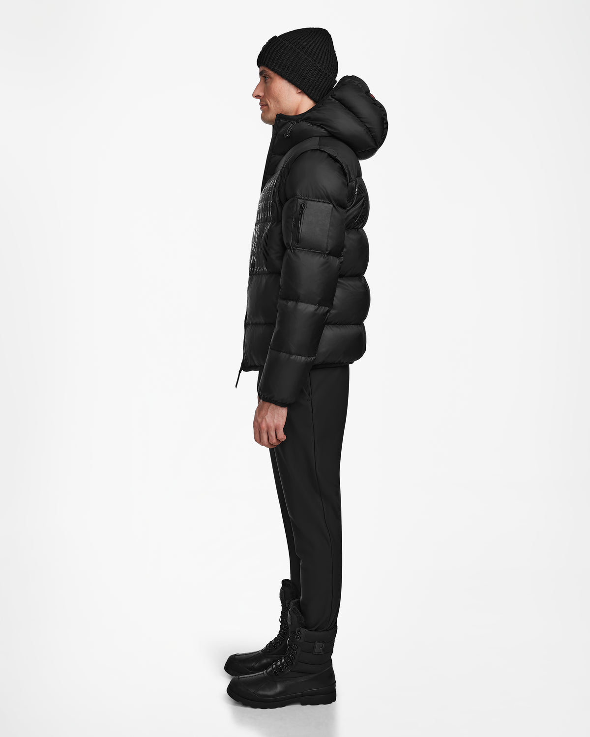 A man in the Rudsak HANS - 6124518 Black men’s down ski jacket stands confidently, prepared for winter with advanced RECCO rescue technology.