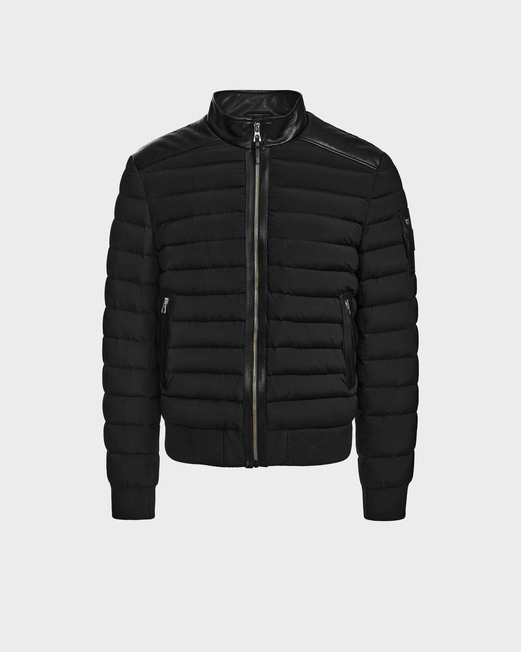 The Rudsak JOSHUA - 6124542 Black is a black quilted bomber-style light down jacket with a front zipper, ribbed cuffs and hem, two zippered side pockets, and a sleek modern design shown on a plain light background.