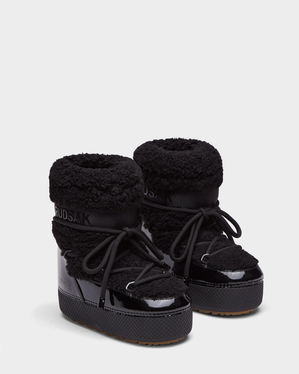 Rudsak KATHY - 8223513 Black women’s winter boots feature sherpa fur texture, shiny patent accents, thick soles, and large laces. These water-repellent boots are shown on a plain white background.