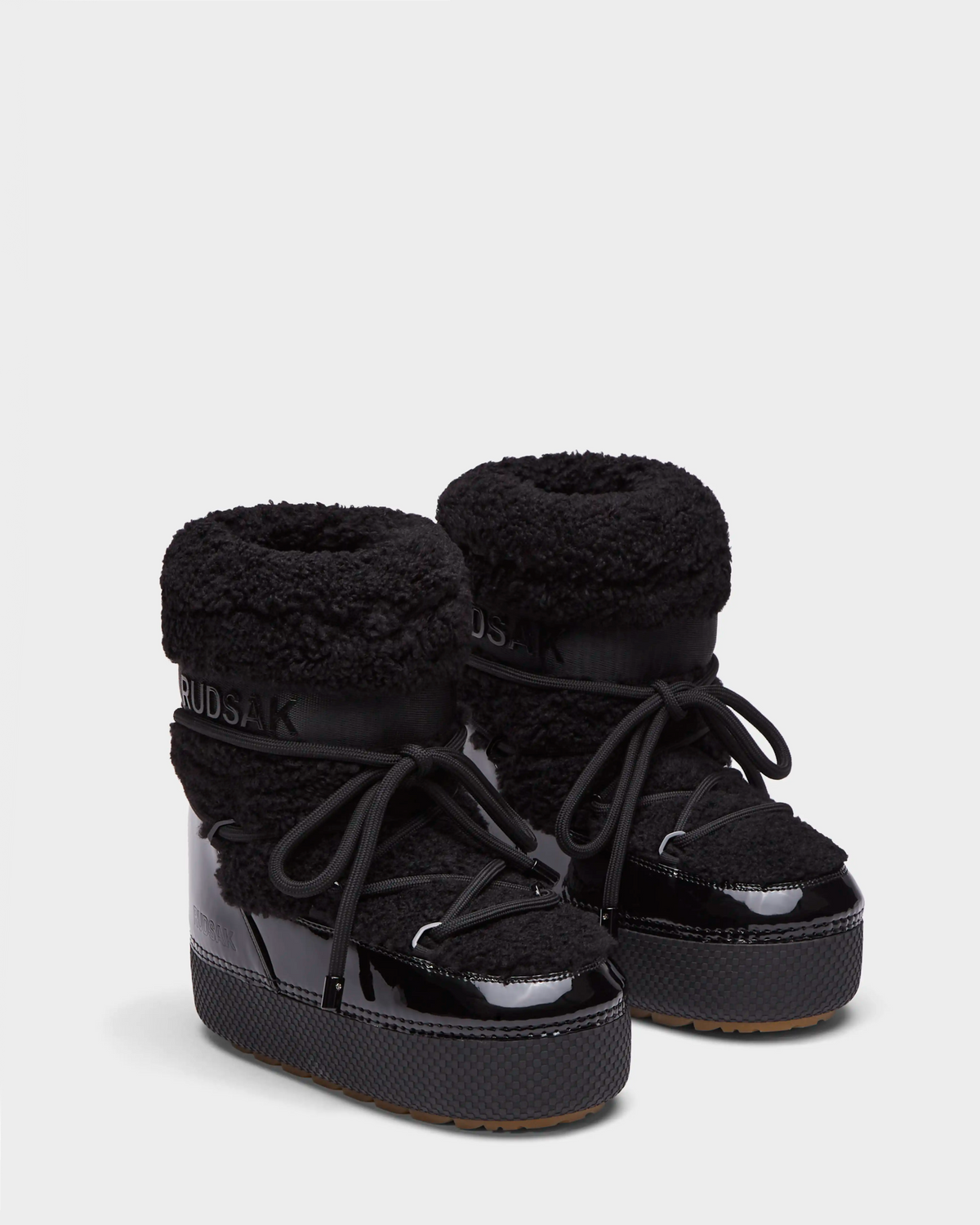 Rudsak KATHY - 8223513 Black women’s winter boots feature sherpa fur texture, shiny patent accents, thick soles, and large laces. These water-repellent boots are shown on a plain white background.
