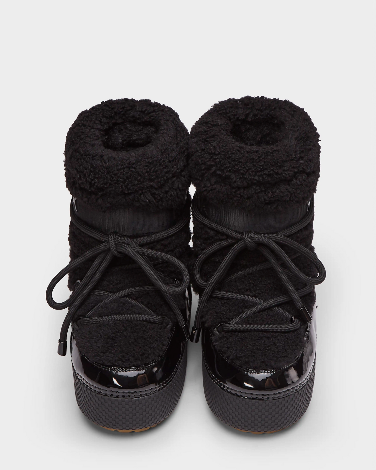 A pair of Rudsak KATHY - 8223513 Black women’s winter boots with fuzzy, textured uppers, glossy rubber toes, and thick laces, shown on a plain white background.