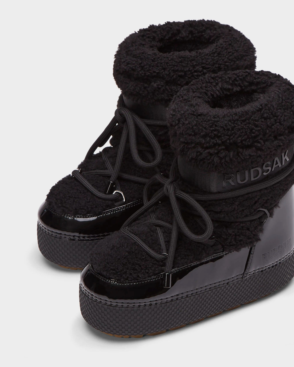 Rudsak KATHY - 8223513 Black women's winter boots feature thick textured fabric, shiny patent details, chunky soles, a water-repellent design, and Rudsak branding on the side and top.