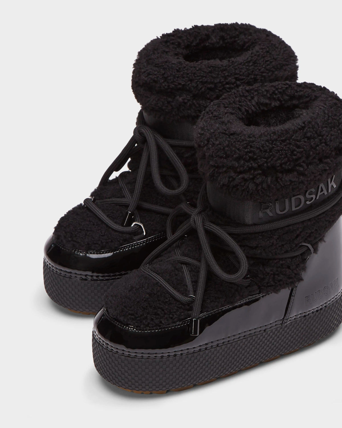 Rudsak KATHY - 8223513 Black women's winter boots feature thick textured fabric, shiny patent details, chunky soles, a water-repellent design, and Rudsak branding on the side and top.