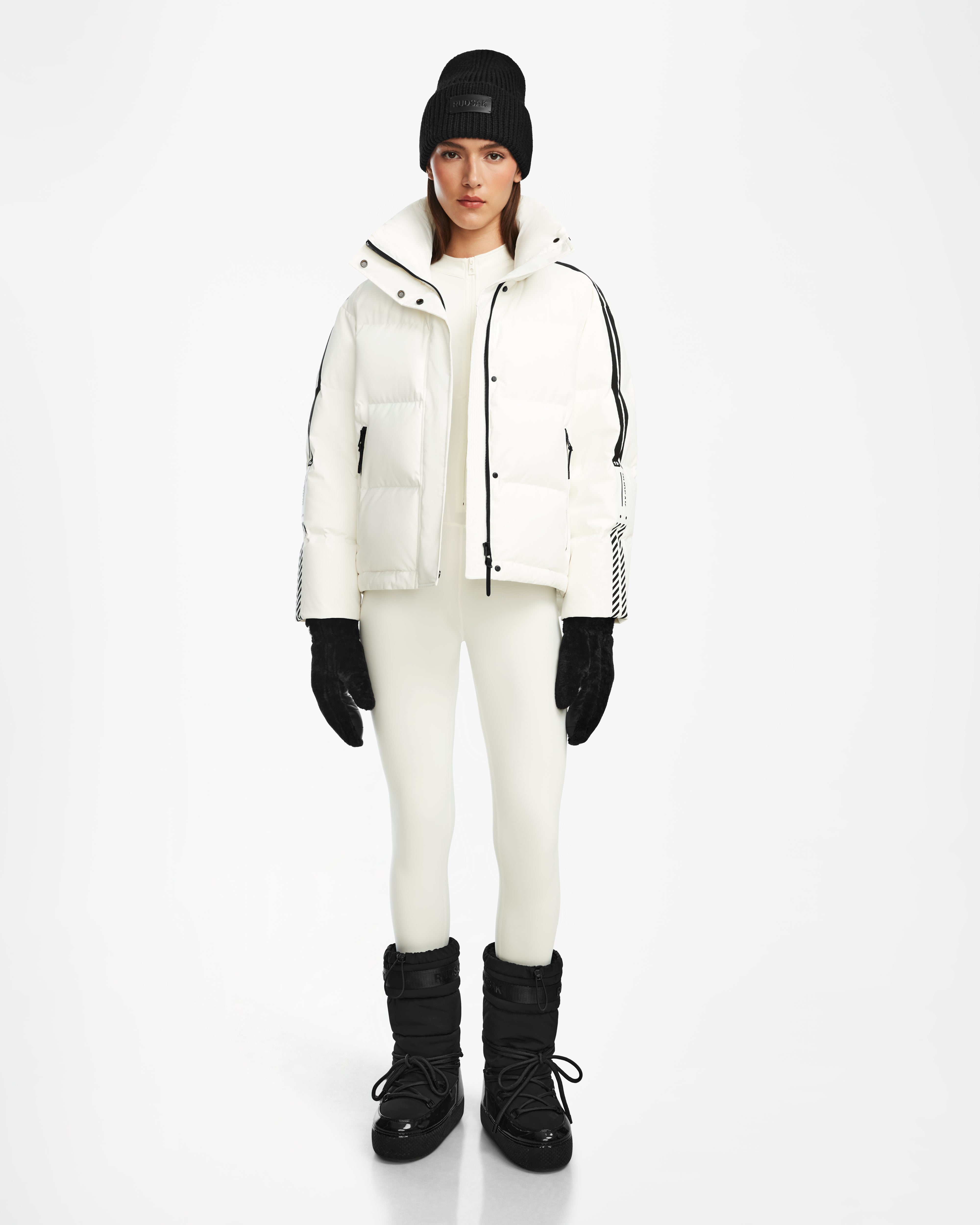 A person stands facing forward against a plain white background, wearing the Rudsak KIMIA - 8124716 Optic White women's down ski jacket.