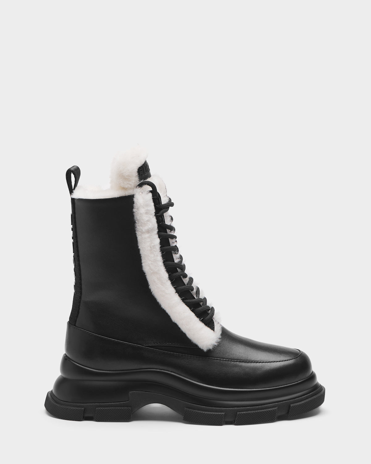 The Rudsak LANA S - 8224537 Black women’s boot features black leather, a chunky sole, and white faux fur lining on the tongue and collar, shown in a side profile against a plain light background.