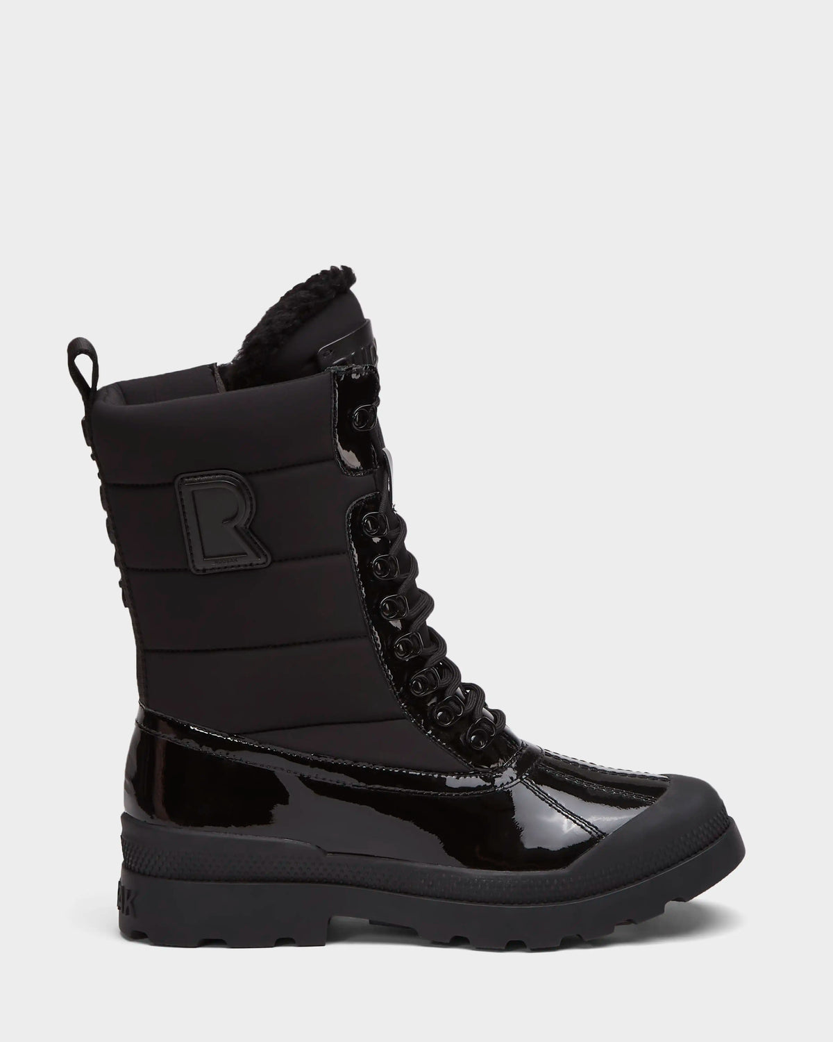 The Rudsak LEX - 8224534 Black is a women’s mid-calf winter boot made of shiny patent and quilted fabric, with a lace-up front, thick treaded sole, back loop tab, raised R logo on the ankle, and water-resistant protection.