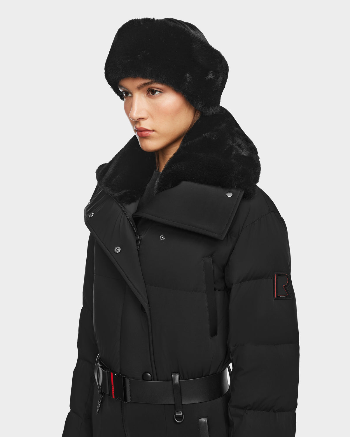 A woman wearing the LOVE - 8124724 Black ski suit and hat by Rudsak, perfect for stylish winter outings.