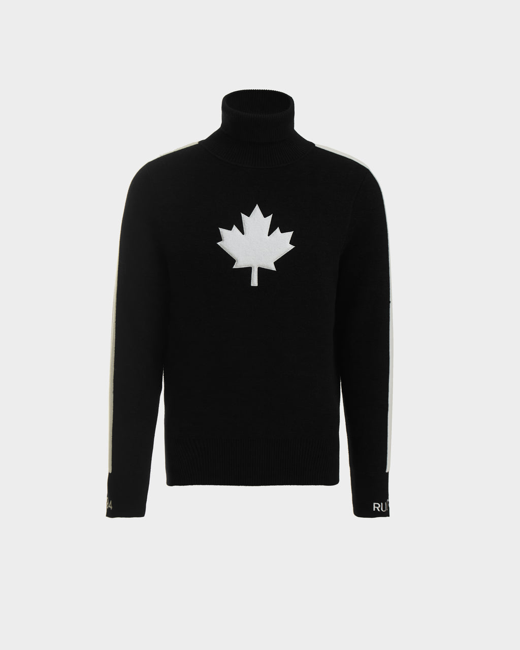 The Rudsak LUKAS - 6524543 Black men’s knit turtleneck sweater features a bold white maple leaf on the chest and white sleeve stripes, ideal for après-ski, shown against a plain light background.