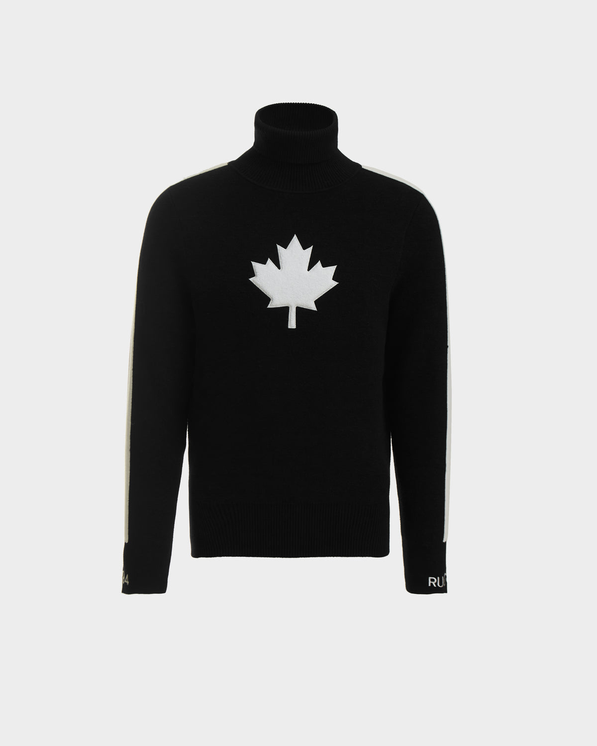 The Rudsak LUKAS - 6524543 Black men’s knit turtleneck sweater features a bold white maple leaf on the chest and white sleeve stripes, ideal for après-ski, shown against a plain light background.