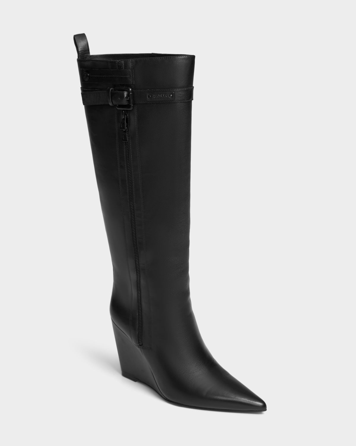 The Rudsak NANCY - 8224507 Black is a womens black leather wedge boot featuring a pointed toe, high shaft, side zipper, and decorative buckle strap near the top. Displayed against a plain light background.