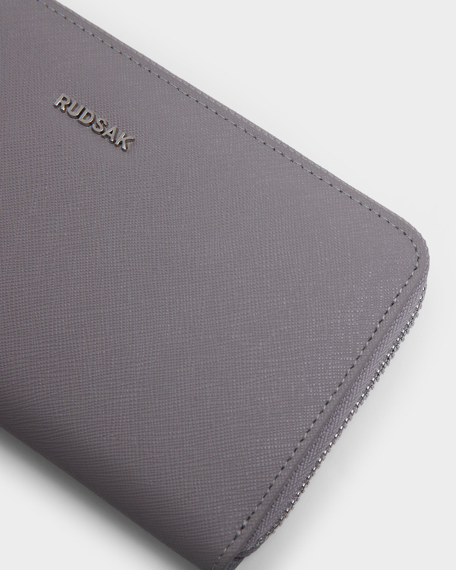 A close-up of the Rudsak NYLA - L424502 Grey women’s leather wallet, showcasing its zippered compartment and organized cardholder slots.
