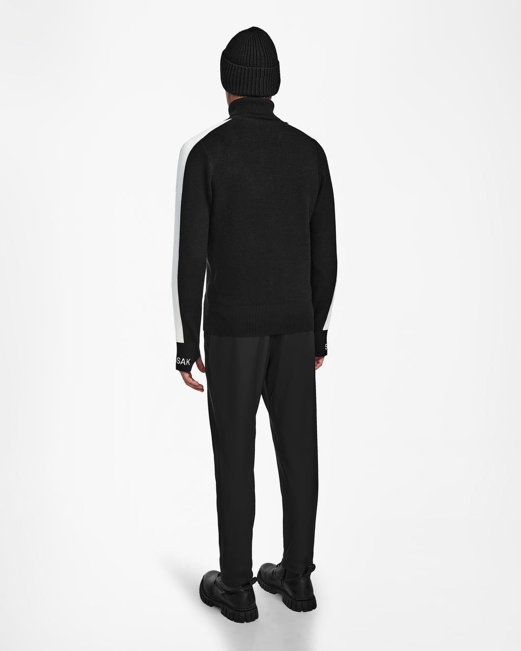 A person stands facing away against a white background, wearing the Rudsak OLIVIER - 6524545 Black jacket, styled with a black knit beanie, black pants, and black shoes.