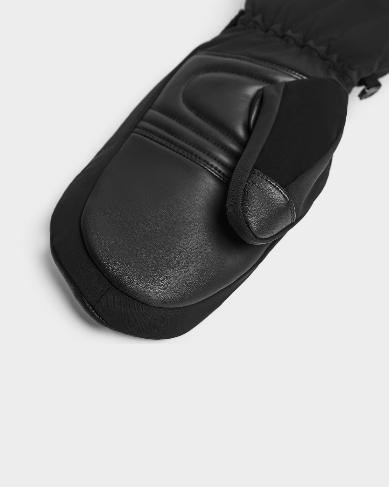 A close-up of the Rudsak OLTEN - 8424513 Black leather ski mitten with visible stitching and smooth texture, displayed on a plain light gray background.
