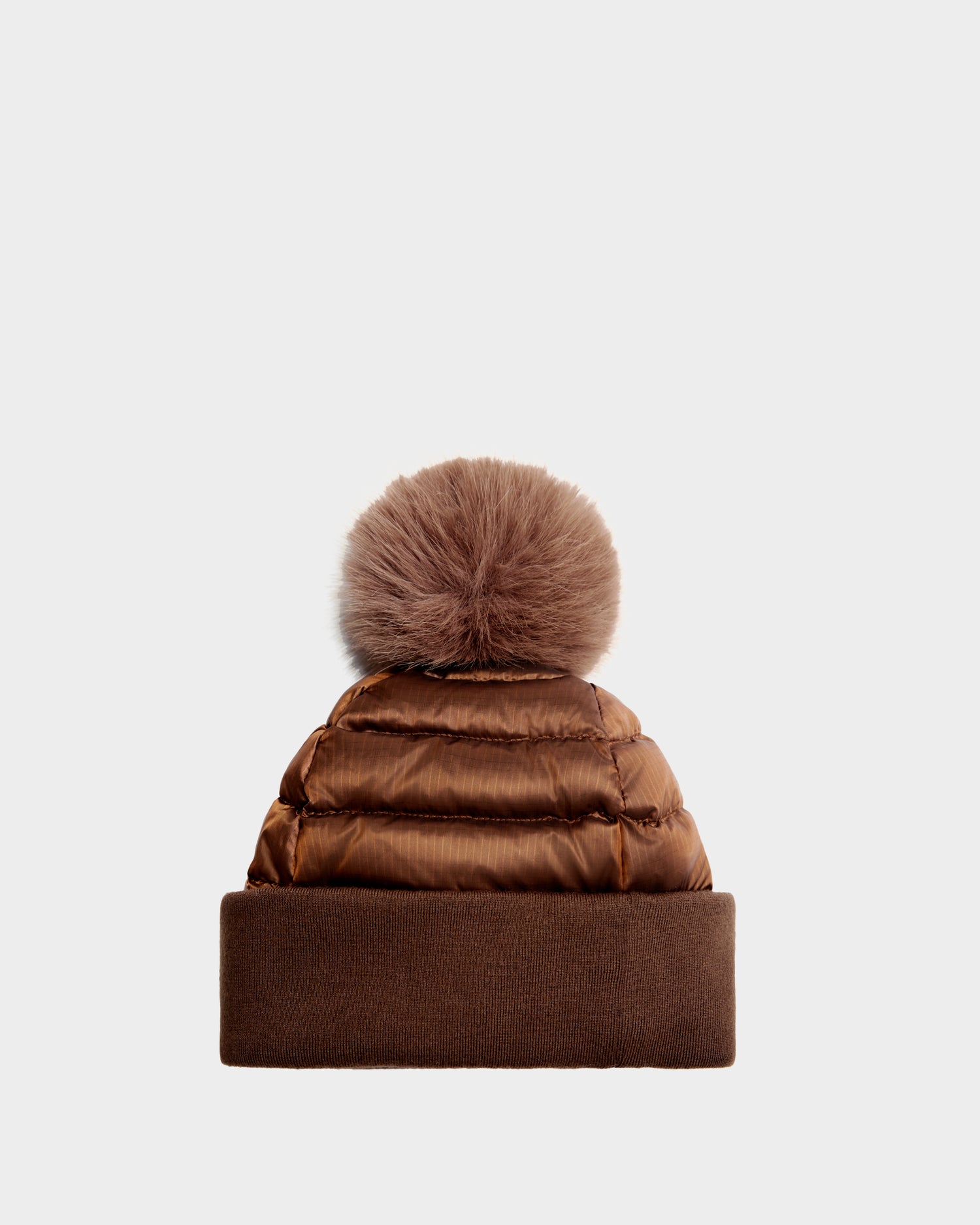 The Rudsak OLYA - 8422504 Antique Bronze is a women’s winter puffer beanie in brown, featuring a wide knit cuff and a large fur pompom, shown against a plain light background.