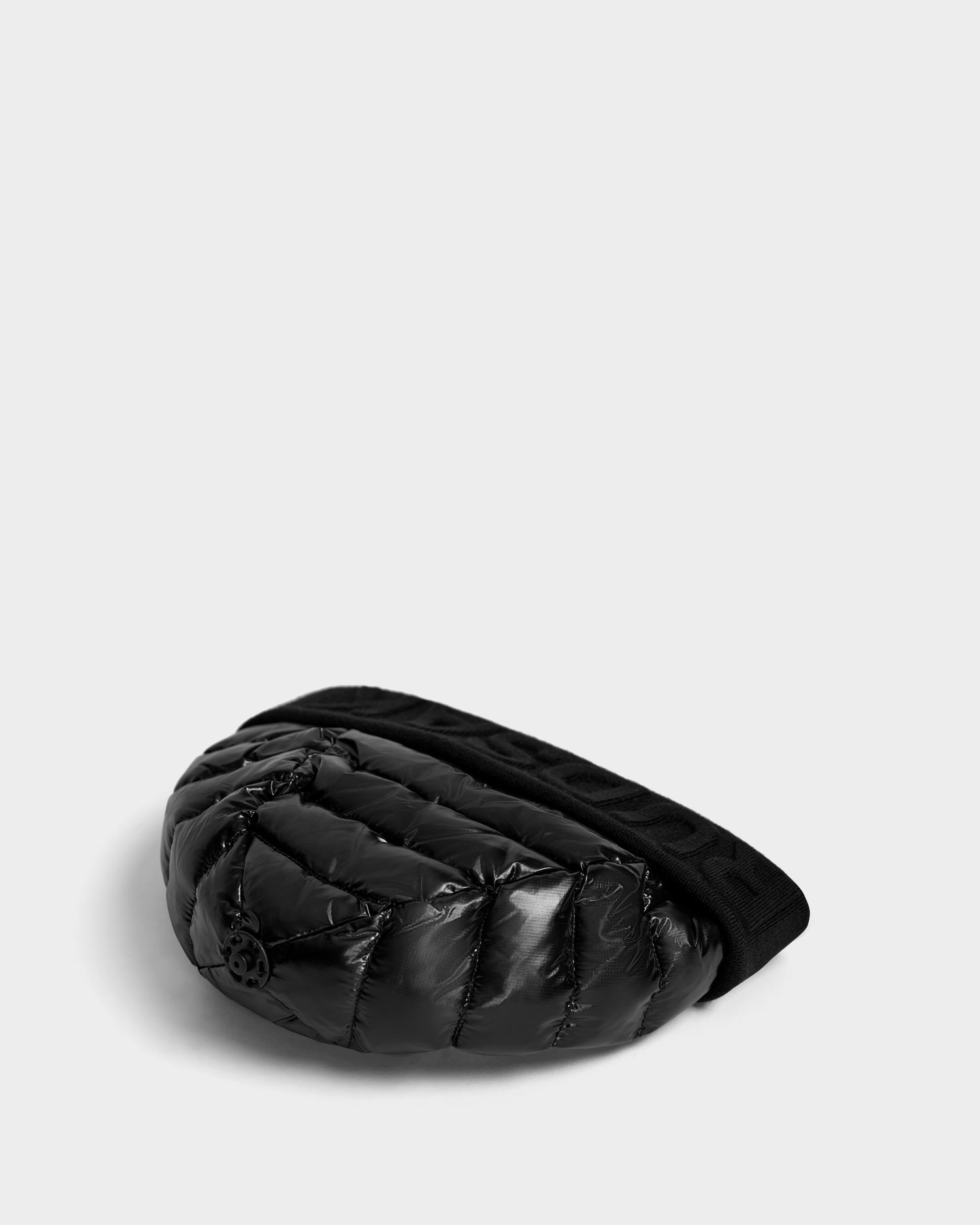 The Rudsak OLYA - 8422504 BLACK is a black, shiny quilted fanny pack with a thick elastic waistband, shown on a light gray background—perfectly complementing womens winter hats or fur pompom accessories for cold-weather style.