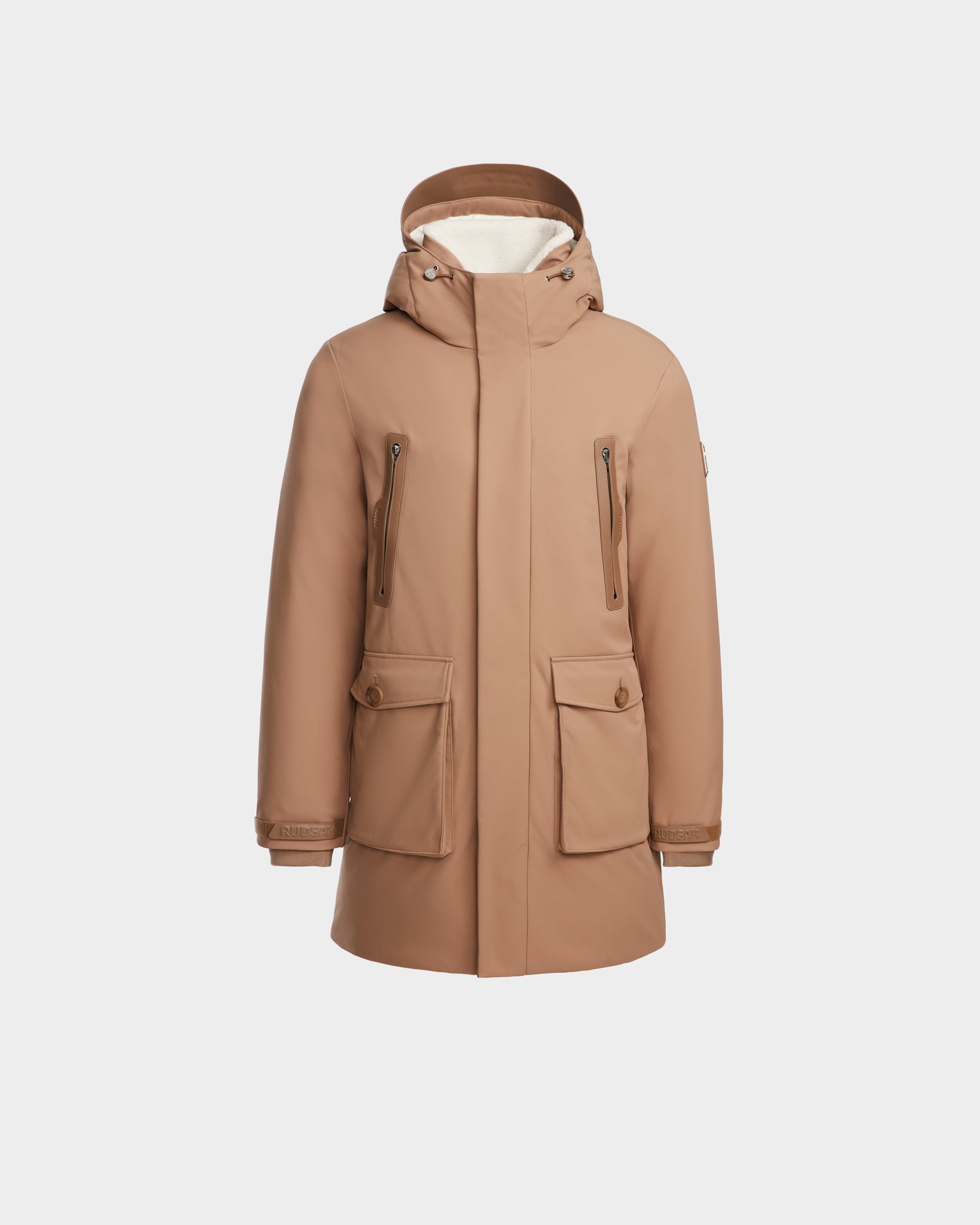 The Rudsak RANI - M124506 Sand is a light brown men's down parka with eco-fill, a hood, front zipper, two bottom buttoned pockets, and two zippered chest pockets—ideal for cold-weather city outings. Shown on a plain white background.