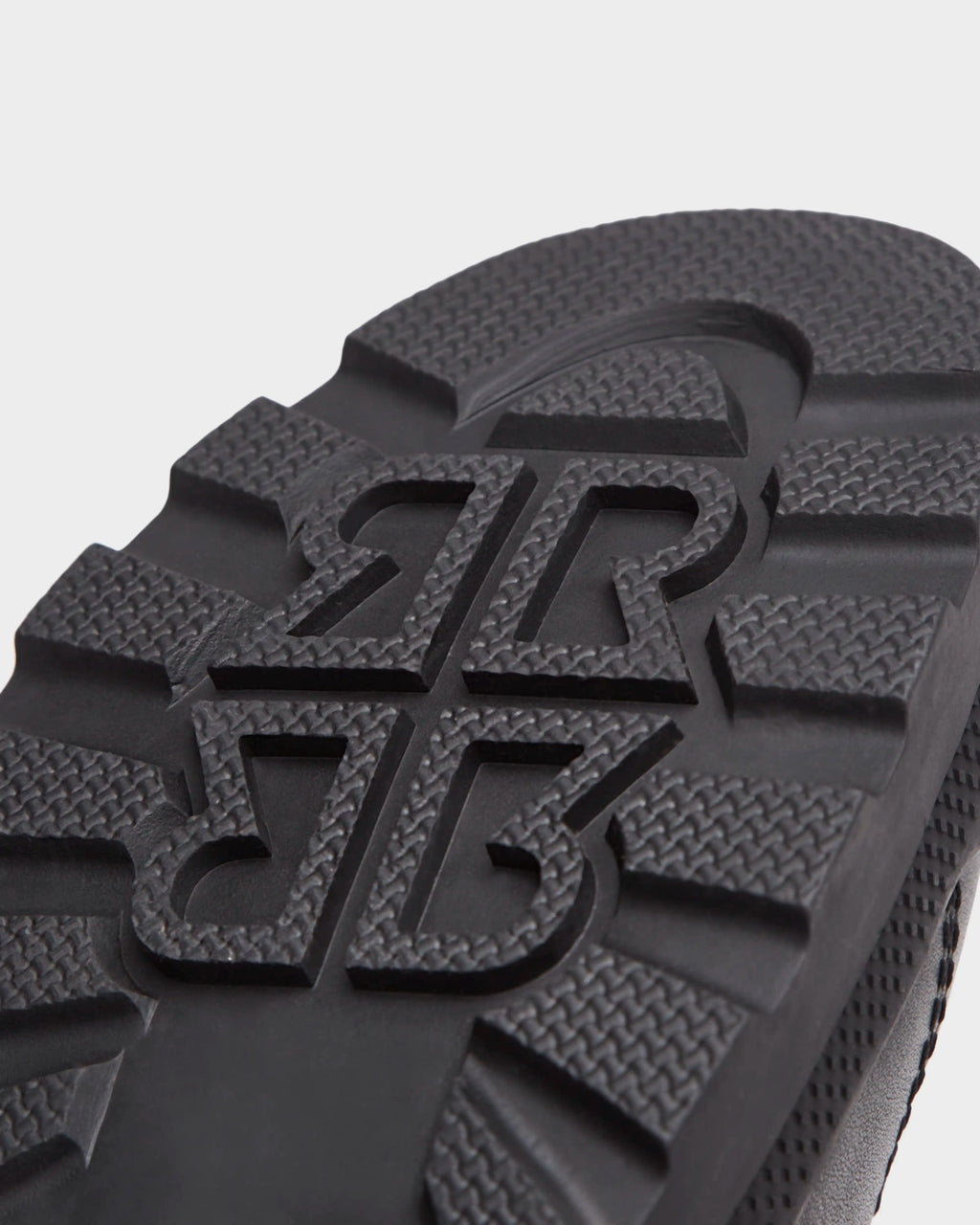 Close-up of the black sole on Rudsaks REAGAN - 6224501 boots, featuring a bold, raised pattern with interlocking BR letters and textured treads for top grip—ideal for men’s winter footwear.