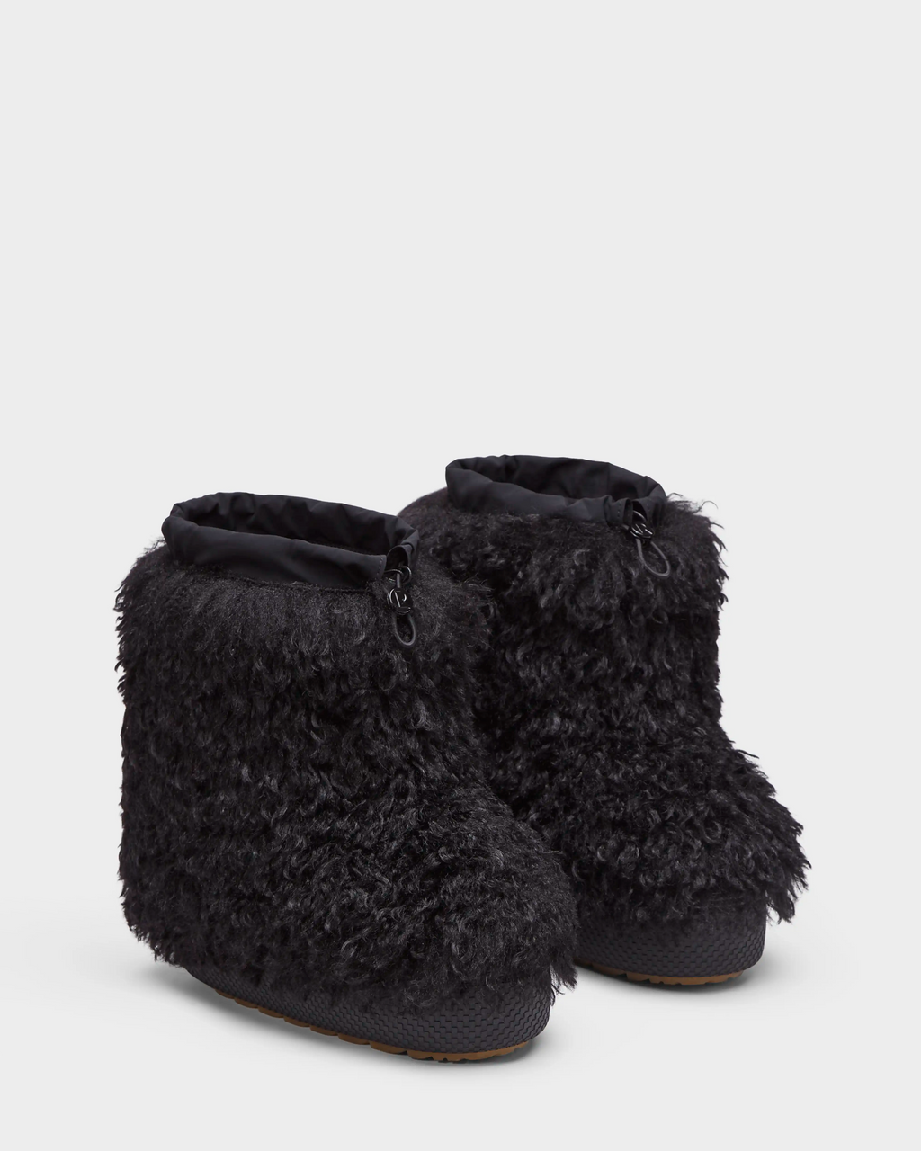 The Rudsak ROSSY - 8224518 Black womens winter boots feature a textured curly faux fur exterior, cozy Mongolian-inspired design, and drawstring closure, shown against a plain white background.