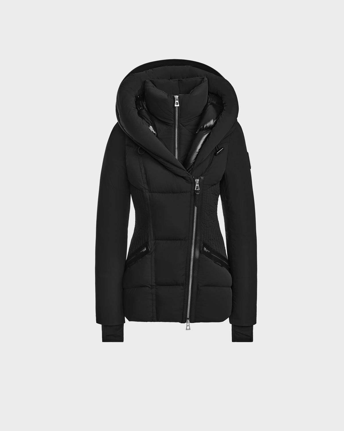 The Rudsak SHALI - 8124588 Black is a womens short down puffer jacket featuring a fitted silhouette, large hood, high collar, and asymmetrical zip closure, shown against a plain light gray background.