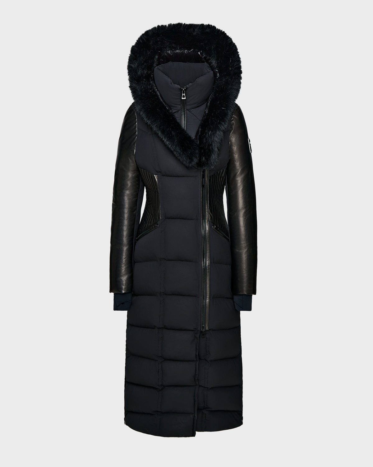 The Rudsak SHANNON - 8121511 BLACK is a long black quilted maxi down parka featuring a faux fur-trimmed hood, leather sleeve accents, and front zipper. Its fitted waist and below-the-knee cut offer stylish warmth for winter days.