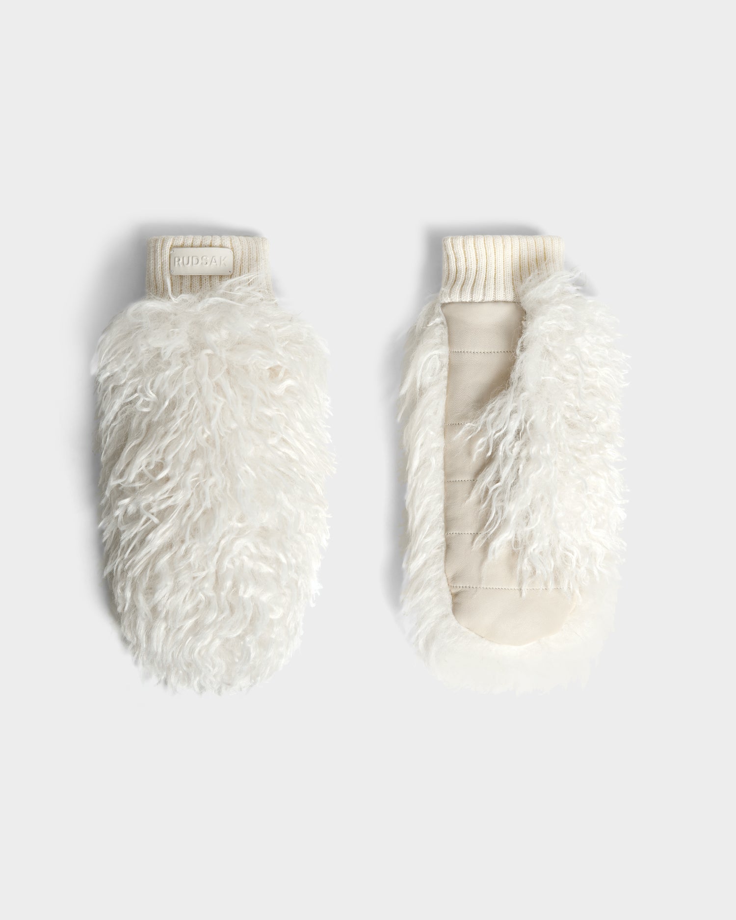 The Rudsak SUSAN M - 8424505 Iceland mittens feature white, fluffy faux Mongolian fur with a shaggy texture and ribbed cuffs—ideal for women’s winter gloves or après-ski style—shown on a light gray background.