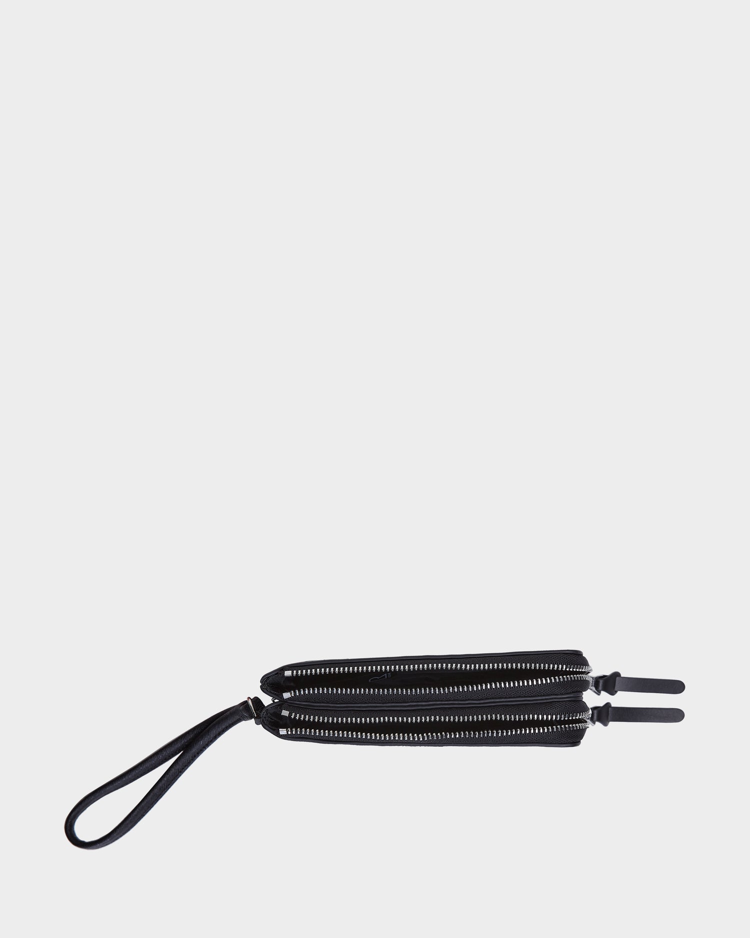 The Rudsak ZURIE - L424501 Black is a women’s leather wristlet wallet with silver zippers, shown on a white background. It features a looped strap at one end and dual zipper pulls for easy access to compartments.